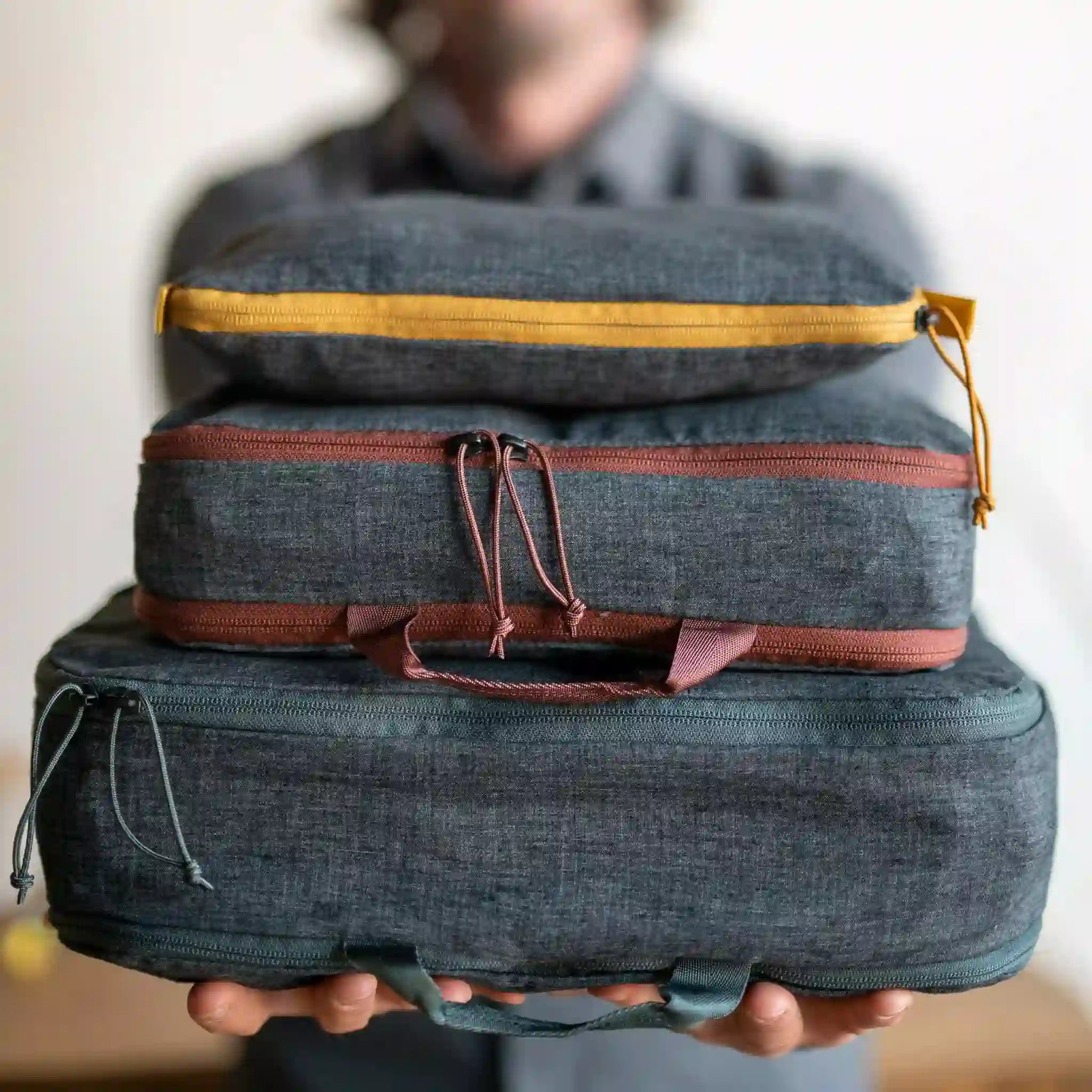 A man holds out a stack of packing Hemp Cubes in various sizes.