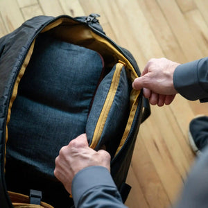 A man organizes his belongings using Hemp Cubes by Boundary Supply.