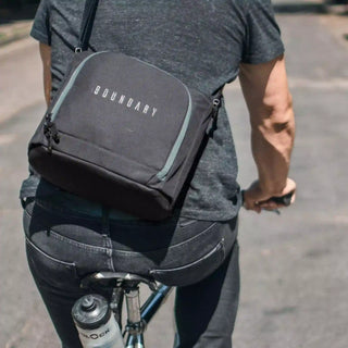 A man riding his bicycle with an MK-2 Camera Cube strapped to his back.