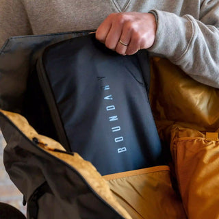 A woman stashes her PK-1 Packing Cube into her backpack.